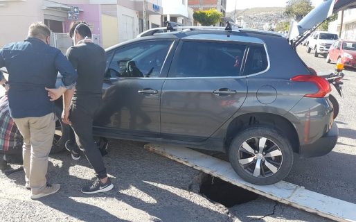 En Rawson y Saavedra se abrió el asfalto y un vehículo rompió el eje delantero