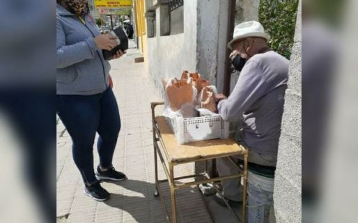 Un abuelo vende tortas fritas afuera de su casa
