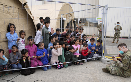 Un soldado entretiene con un ukelele a niños afganos evacuados