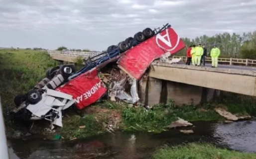Un camión volcó y quedó colgando de un puente
