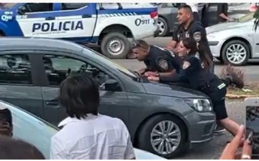 La salvaje actitud de un grupo de jóvenes: arrastraron a dos efectivos en el capot del auto