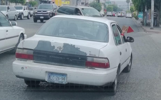 Una así barba: como su auto no tiene guiño, la novia lo ayuda sacando un cartel por la ventana