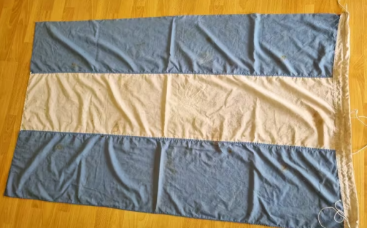 La bandera que se salvó de la requisa de los soldados ingleses protegida por dos veteranos de Malvinas